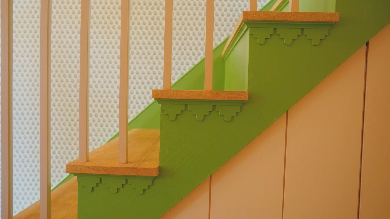 Green staircase with natural timber treads and patterned wallpaper