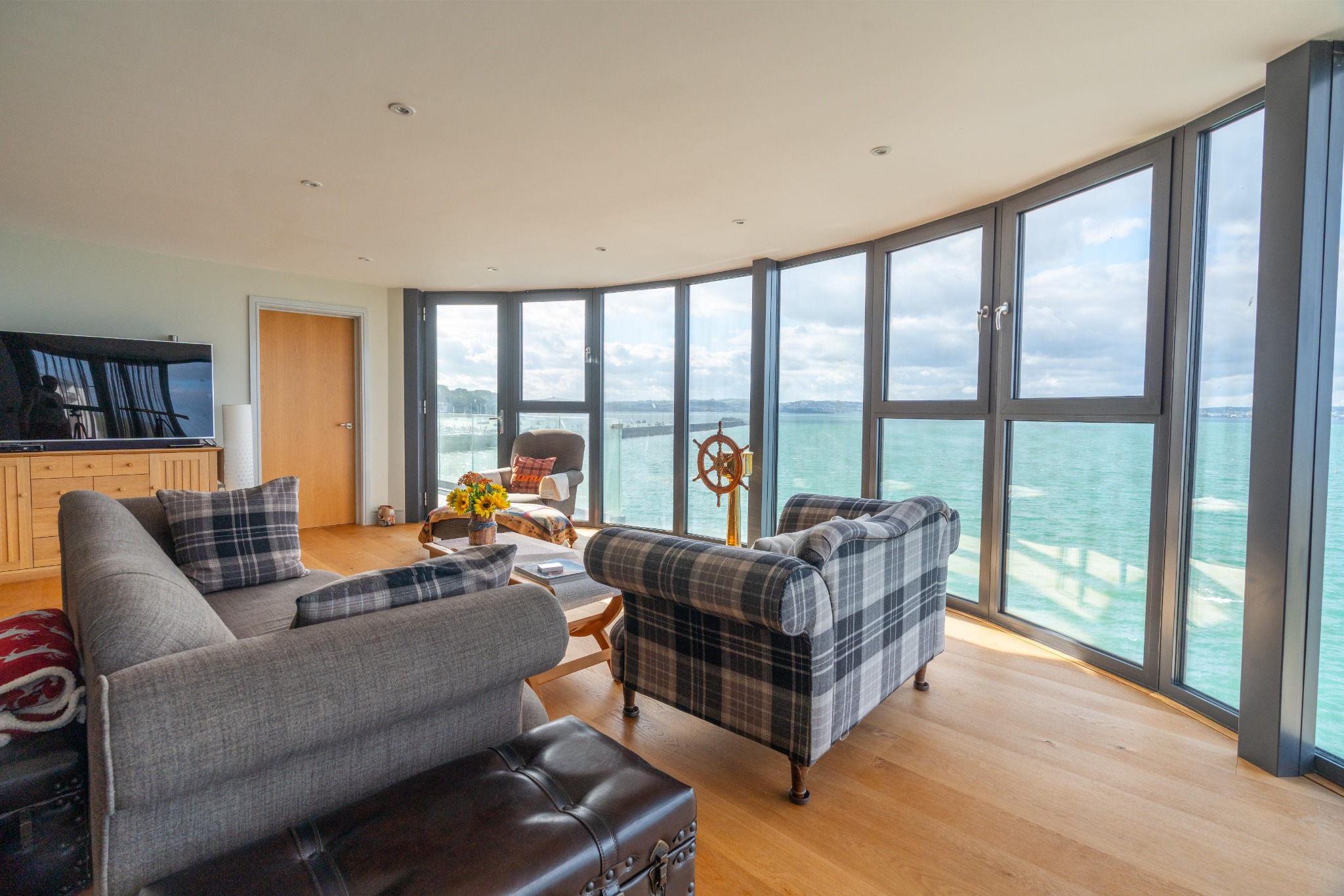 Waypoint’s sitting room with curved floor-to-ceiling windows overlooking Tor Bay