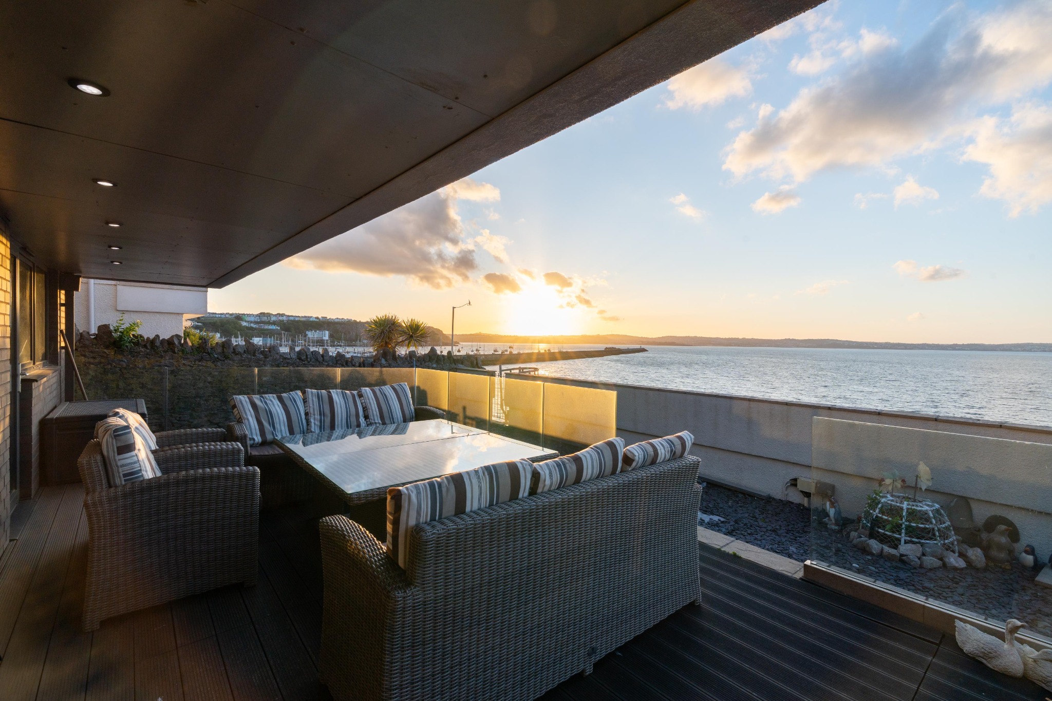 Waypoint’s sheltered sea-facing terrace with outdoor seating in evening light